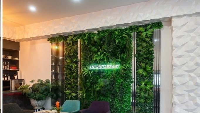 ANI Restaurant – Grüne Pflanzenwand mit ANI Neon-Schild